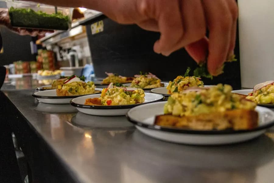 A volunteer plating up dishes during dinner service